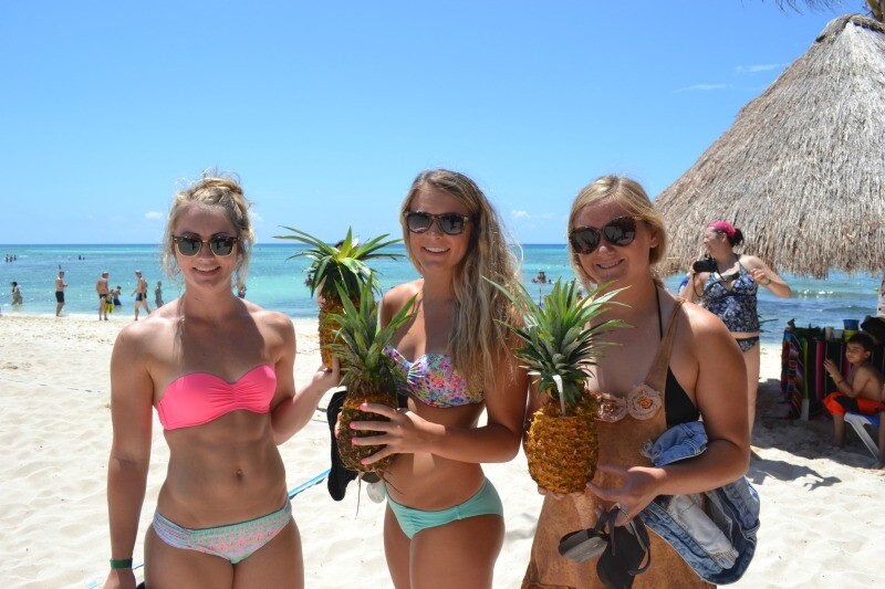 Girls in bikinis with pineapple drinks